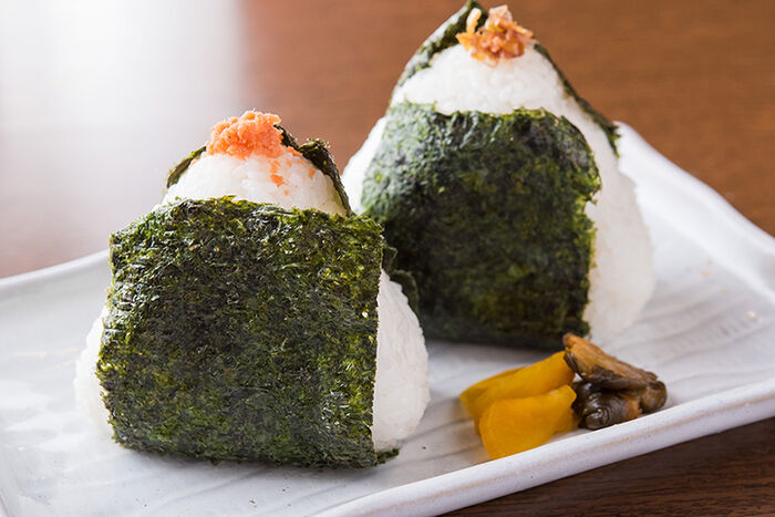 Onigiri triangulares com nori e recheio — comida de rua clássica